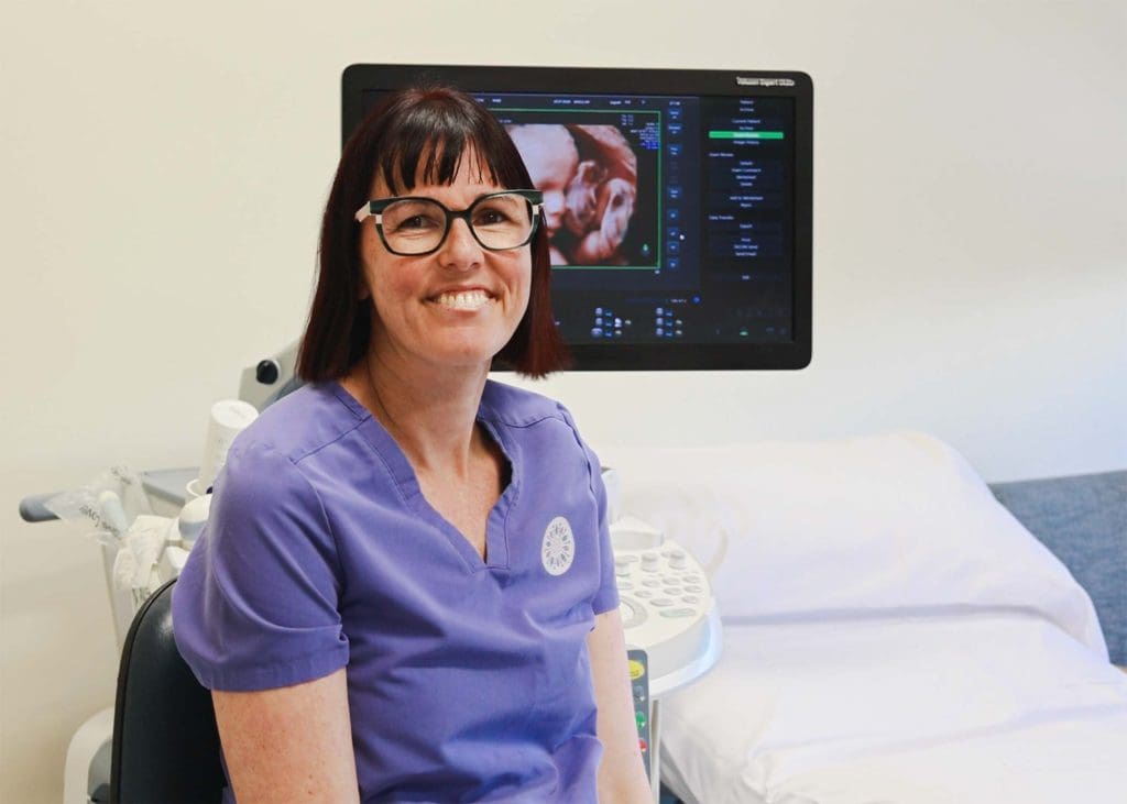 Dr Cecelia O’Brien, specialist women’s health ultrasound doctor, standing beside ultrasound machine in North Queensland clinic