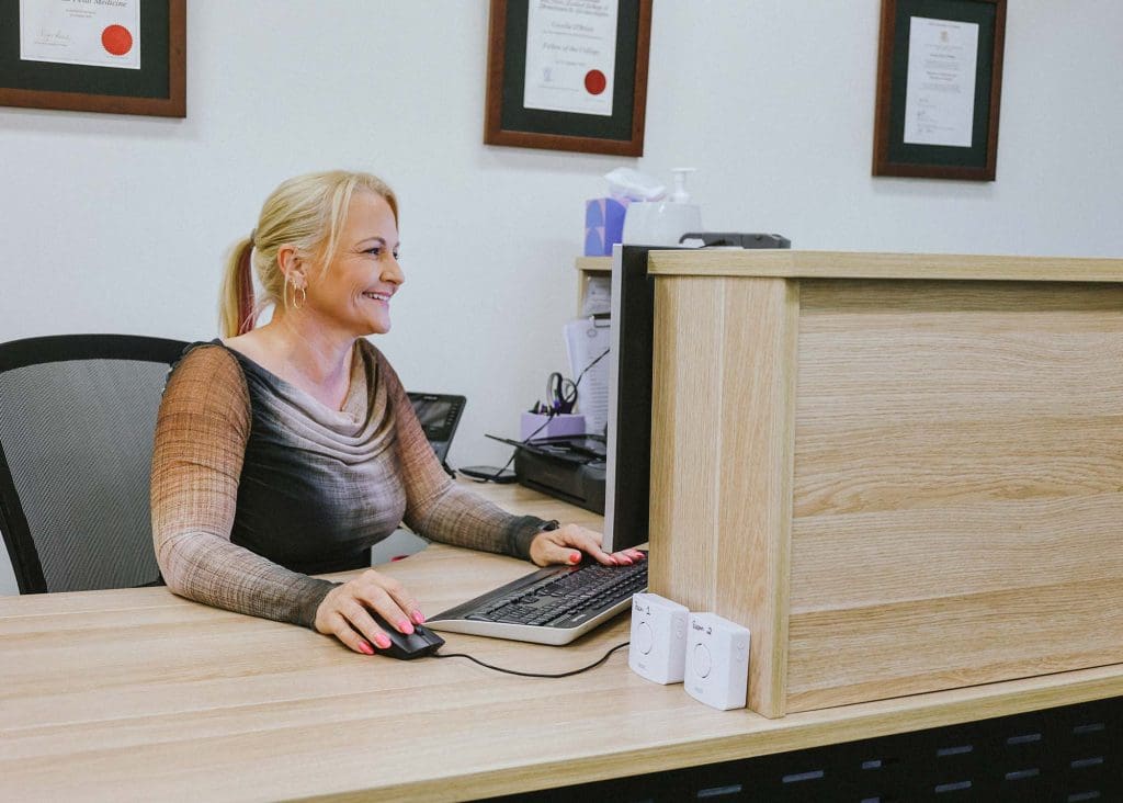 Rebecca, practice manager at reception desk at Women’s Health Circle clinic supporting specialist ultrasound services in North Queensland